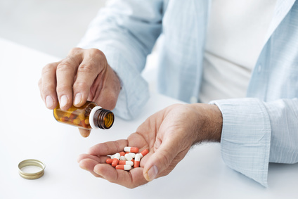 Personne tenant une poignée de médicaments dans sa main